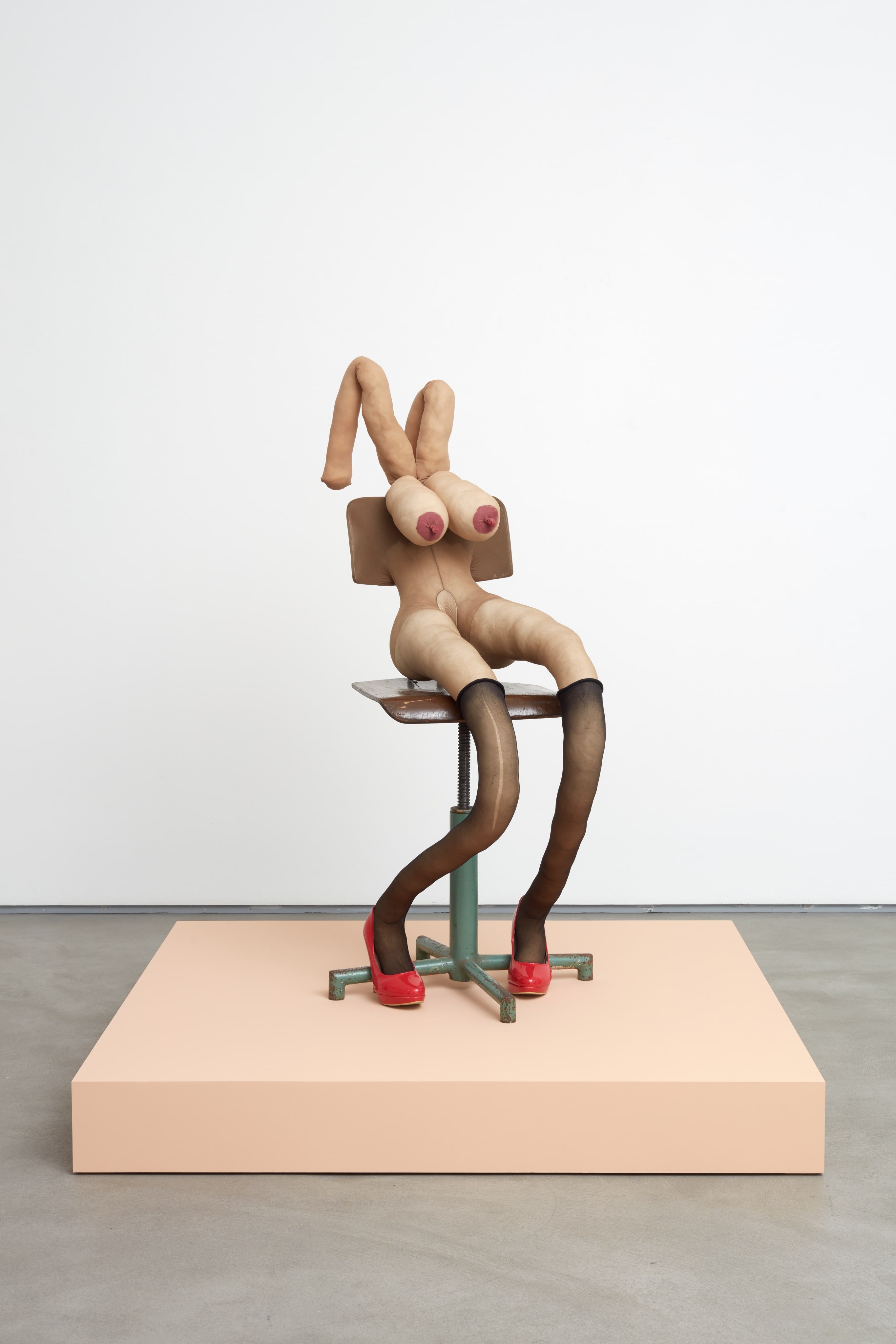 “Tracey” (2018). Collants, kapok, fil, chaussures et chaise en bois et métal. Sculpture : 122 x 53 x 71 cm. Socle : 121,9 x 121,9 x 15,2 cm. Vue de l’exposition Honey Pie (2020) à la galerie Sadie Coles HQ à Londres. 
