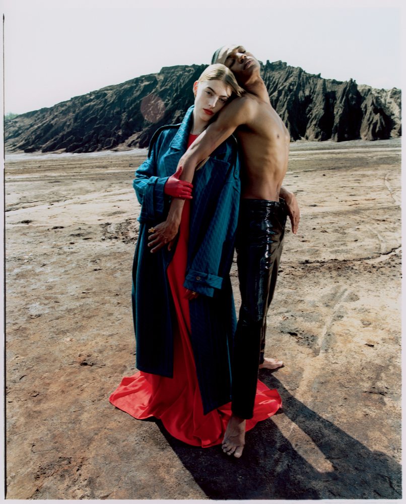 Les mannequins Berit Heitmann et Michael-John Harper dans la série “Vent du nord” réalisée par Dan Beleiu. Manteau en laine, MISSONI. Robe en satin, RABIH KAYROUZ. Lui : pantalon en cuir verni, ACNE STUDIOS.