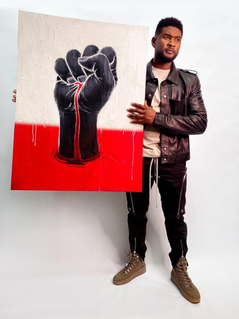 Usher with his and James Jean's sign “Can't Breath” for the “Show Me the Signs” auction. Photo courtesy of the African American Policy Forum.