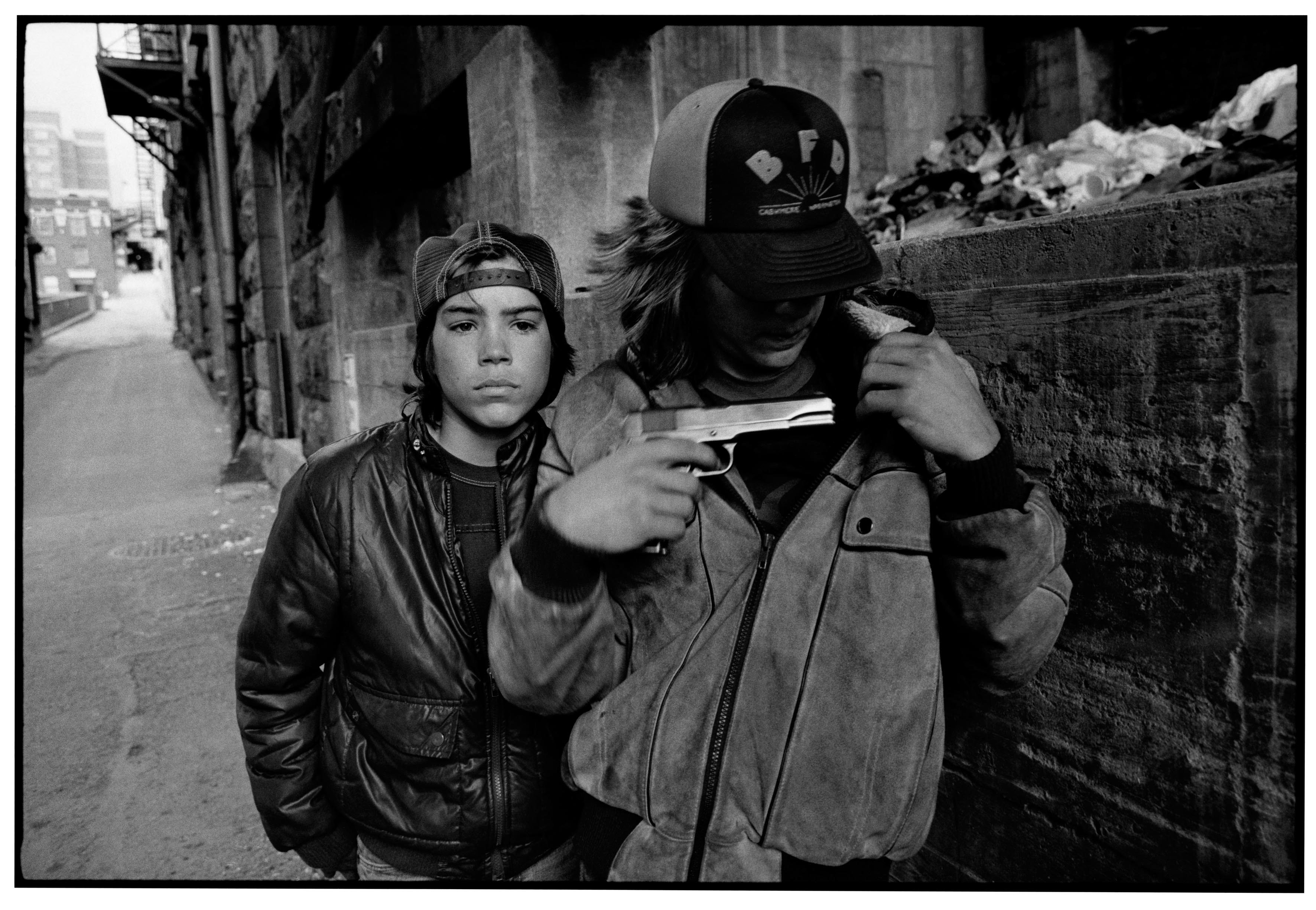 “Rat” and Mike with a gun.” Seattle, 1983. © Mary Ellen Mark Foundation.
