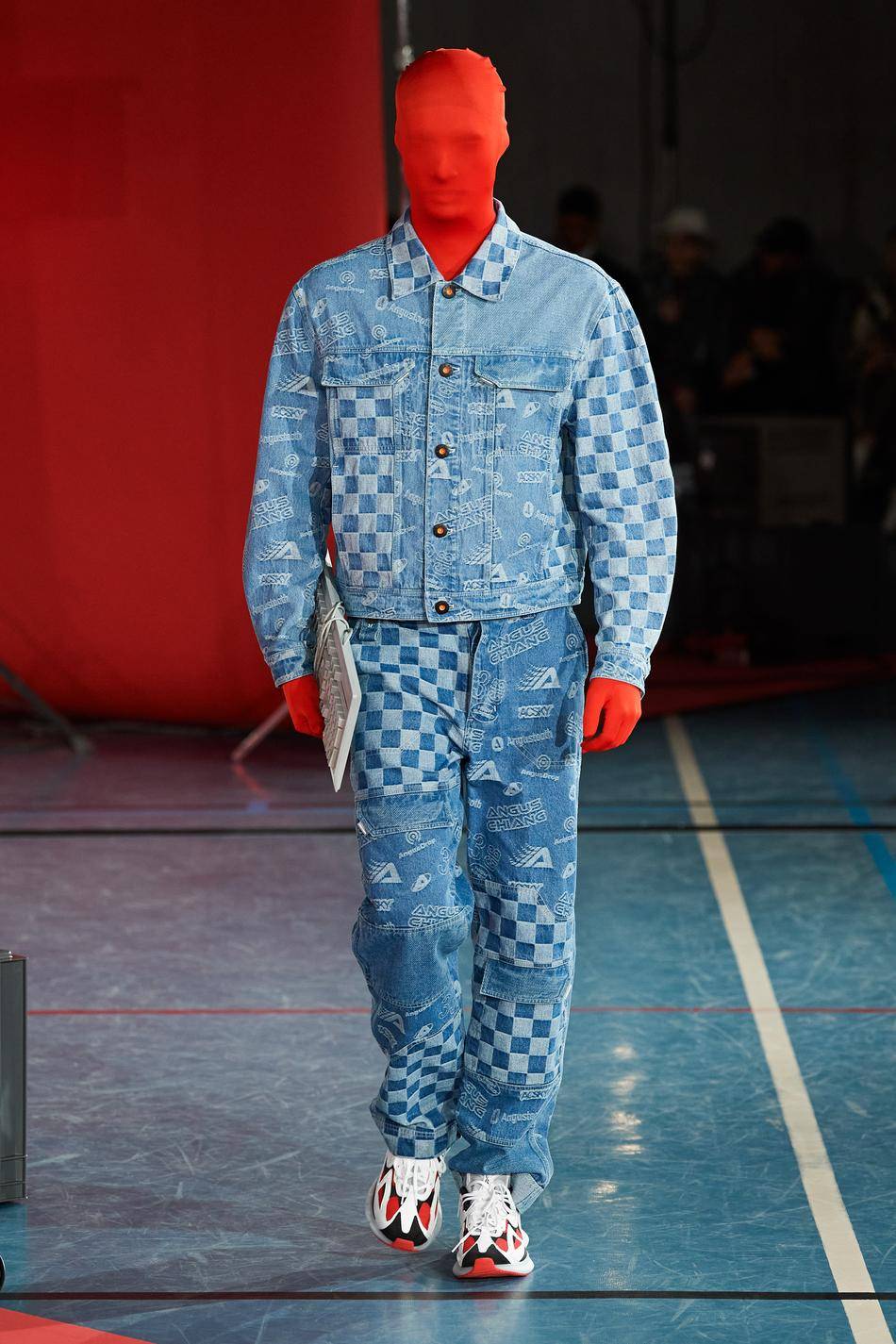Au sein d’une collection hyper-colorée aux accents futuristes, le Taïwanais Angus Chiang découpe veste et pantalon dans un denim bleu ciel recouvert de logos et de damiers en alternance.