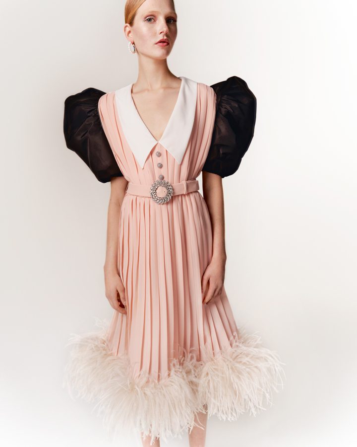 31/80 : Une robe de jour des années 70 en crêpe plissé rose pâle , customisée avec des des manches en faille de soie noire, une ceinture ornée de cristaux, un col en crêpe blanc et un ourlet de plumes sur la jupe. Disponible chez Miu Miu Londres.

