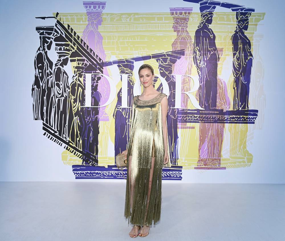 Beatrice Boroomeo wore a Dior Haute Couture Spring-Summer 2020 column dress with tiers of fringe and interlacing embroidery; shorts in gold lamé ottoman. She also wore a Dior Haute Couture headband and Dior sandals.