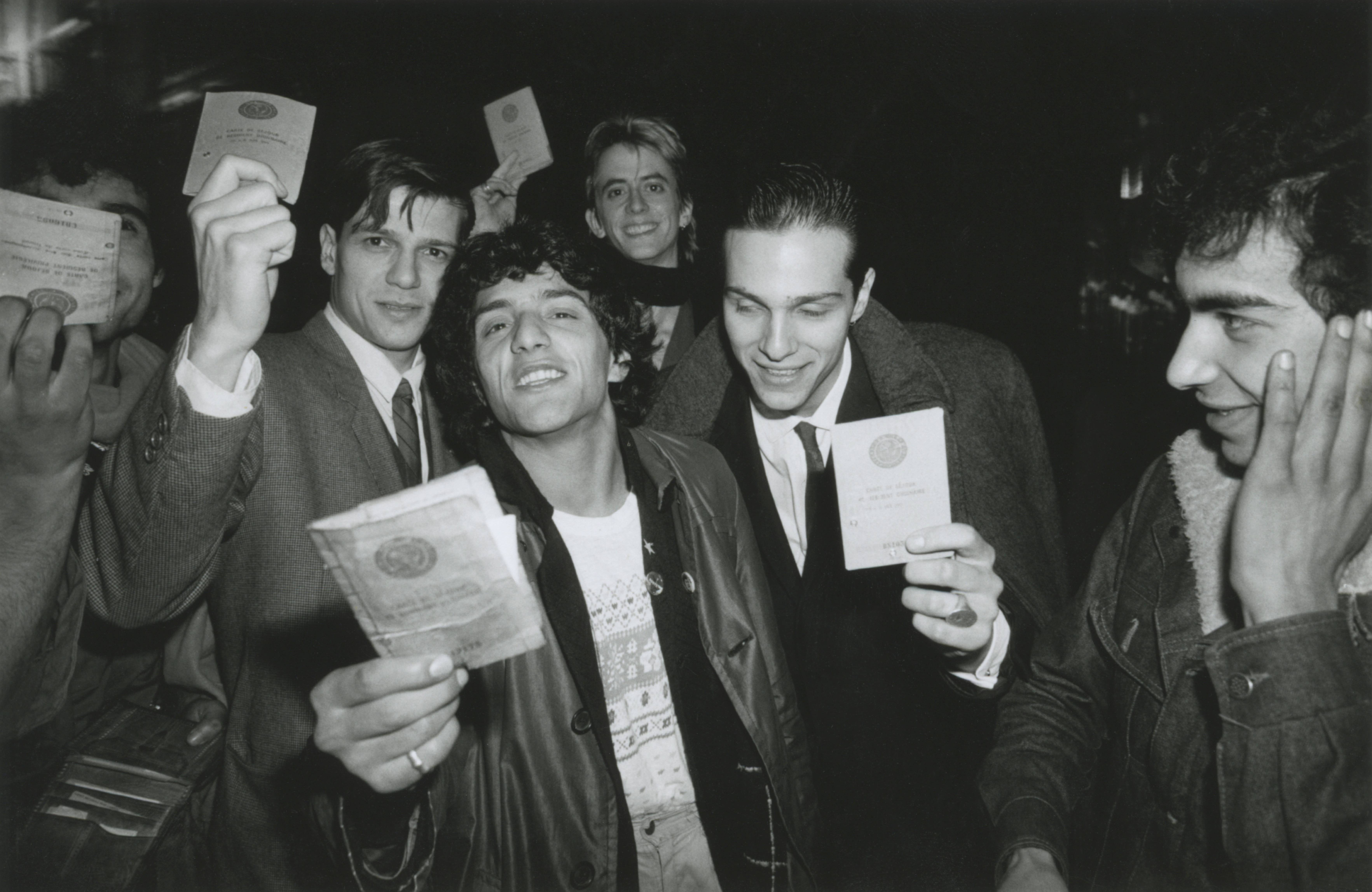 Rachid Taha montrant sa carte de séjour, avec les musiciens chiliens de Corazon Rebelde et le chanteur américain Theo Hakola, aux Transmusicales de Rennes, Rennes, 1981 @ Pierre René-Worms 