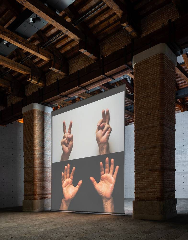 Vue de l’exposition “Bruce Nauman: Contrapposto Studies” à la Punta della Dogana, Venise (2021). Œuvre vidéo “For Beginners (all the combinations of the thumb and fingers)” [2010] de Bruce Nauman. Collection du Los Angeles County Museum of Art et Collection Pinault. Photo : Marco Cappelletti © Palazzo Grassi © Bruce Nauman by SIAE 2021. Courtesy of Sperone Westwater (New York)
