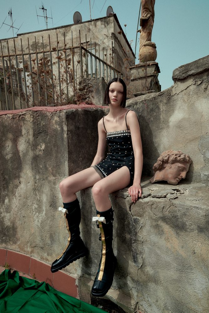 La mannequin Shayna McNeill dans la série “Sur les toits” par Sofia Sanchez et Mauro Mongiello. Robe en laine brodée de strass et de clous, MIU MIU. Bottes, LOUIS VUITTON.