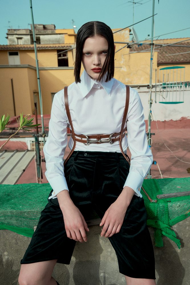 La mannequin Shayna McNeill dans la série “Sur les toits” par Sofia Sanchez et Mauro Mongiello. Chemise en coton, short en velours et harnais, GUCCI.