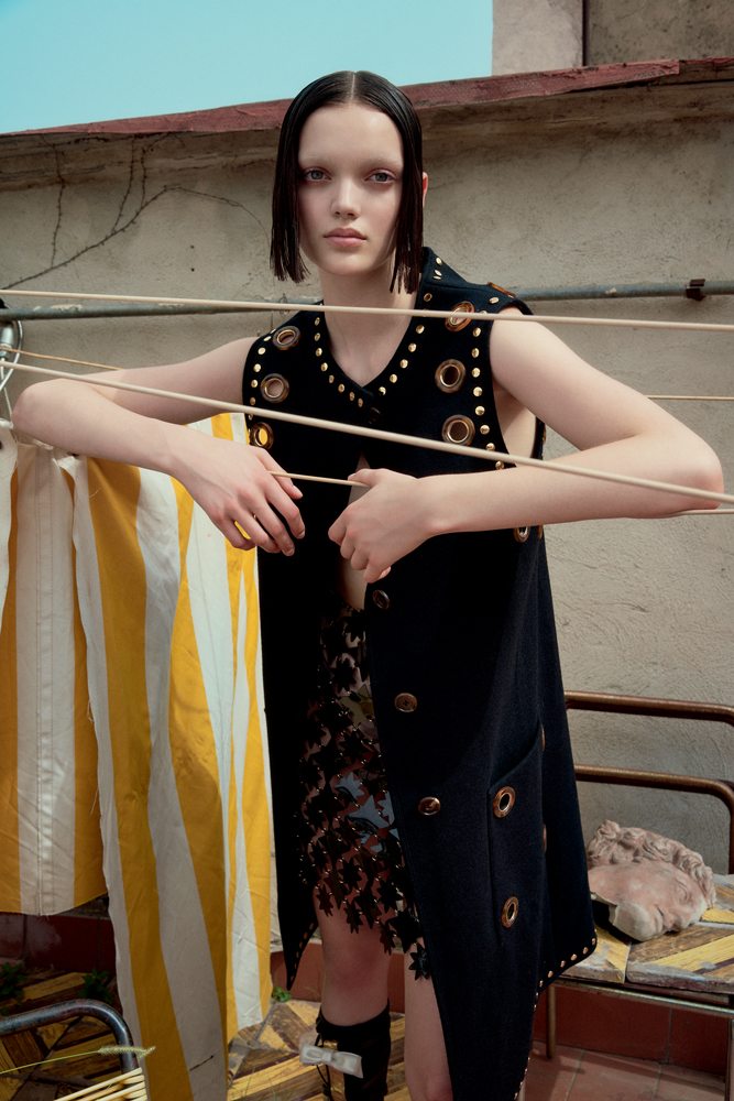La mannequin Shayna McNeill dans la série “Sur les toits” par Sofia Sanchez et Mauro Mongiello. Manteau en drap de laine orné de clous et d’œillets, BURBERRY. Jupe en PVC, PACO RABANNE.