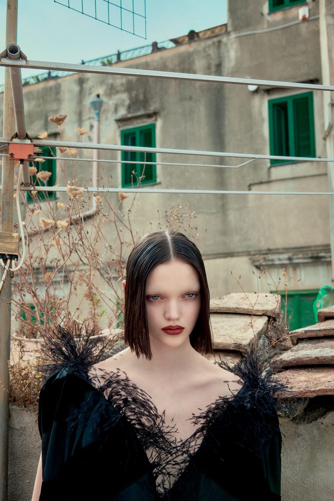 La mannequin Shayna McNeill dans la série “Sur les toits” par Sofia Sanchez et Mauro Mongiello. Robe en laine mélangée, velours et plumes, SAINT LAURENT PAR ANTHONY VACCARELLO.