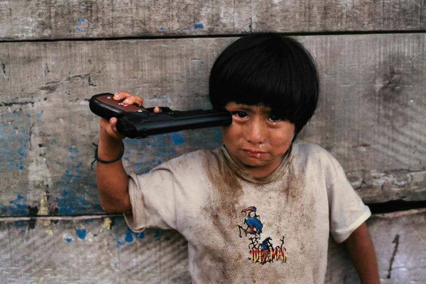 « Young Boy Holding Toy Gun To His Head » taken of Alto Churumazu,  in Yanesha, Peru 2004 © Steve McCurry