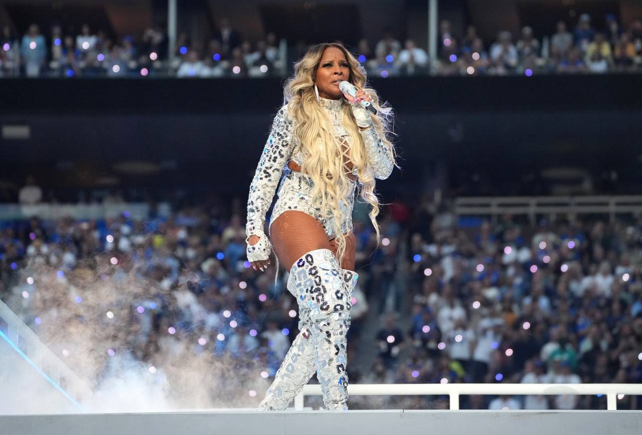 Mary J. Blige is wearing a long-sleeved top, white and sliver shorts with lace details and Swarovski crystals by Peter Dundas, paired with a fedora-style hat, gloves, and Dundas by Serge Rossi thigh-high boots. © Photo by Kevin Mazur/Getty Images for Roc Nation.