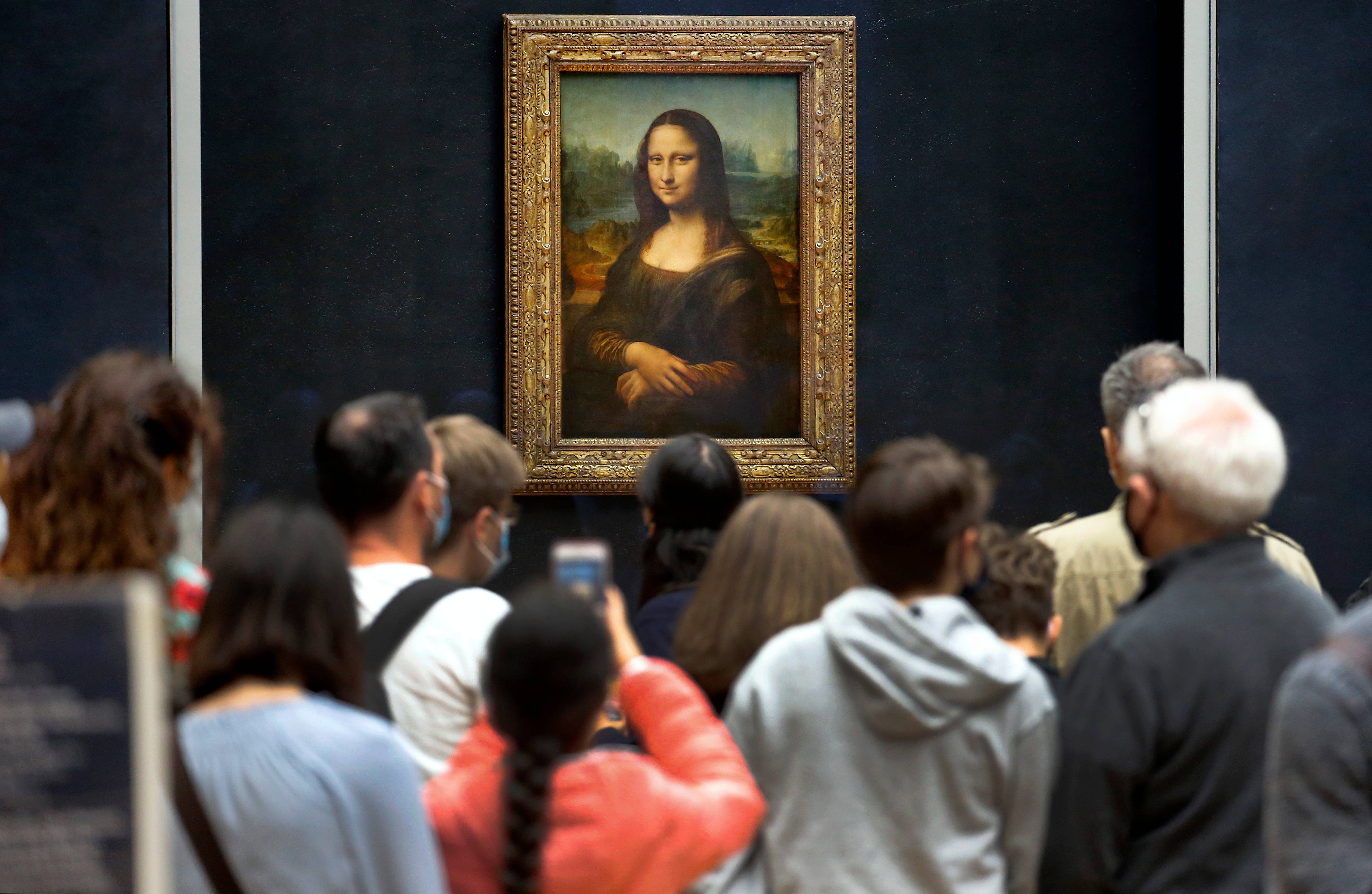 The Mona Lisa by Leonardo da Vinci surrounded by a crowd of visitors in July 2020 at the Louvre, Paris. @ Chesnot/Getty Images.