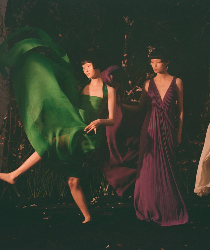 De gauche à droite : robe en organza de soie, DIOR. Robe en crêpe de soie plissé, VALENTINO.