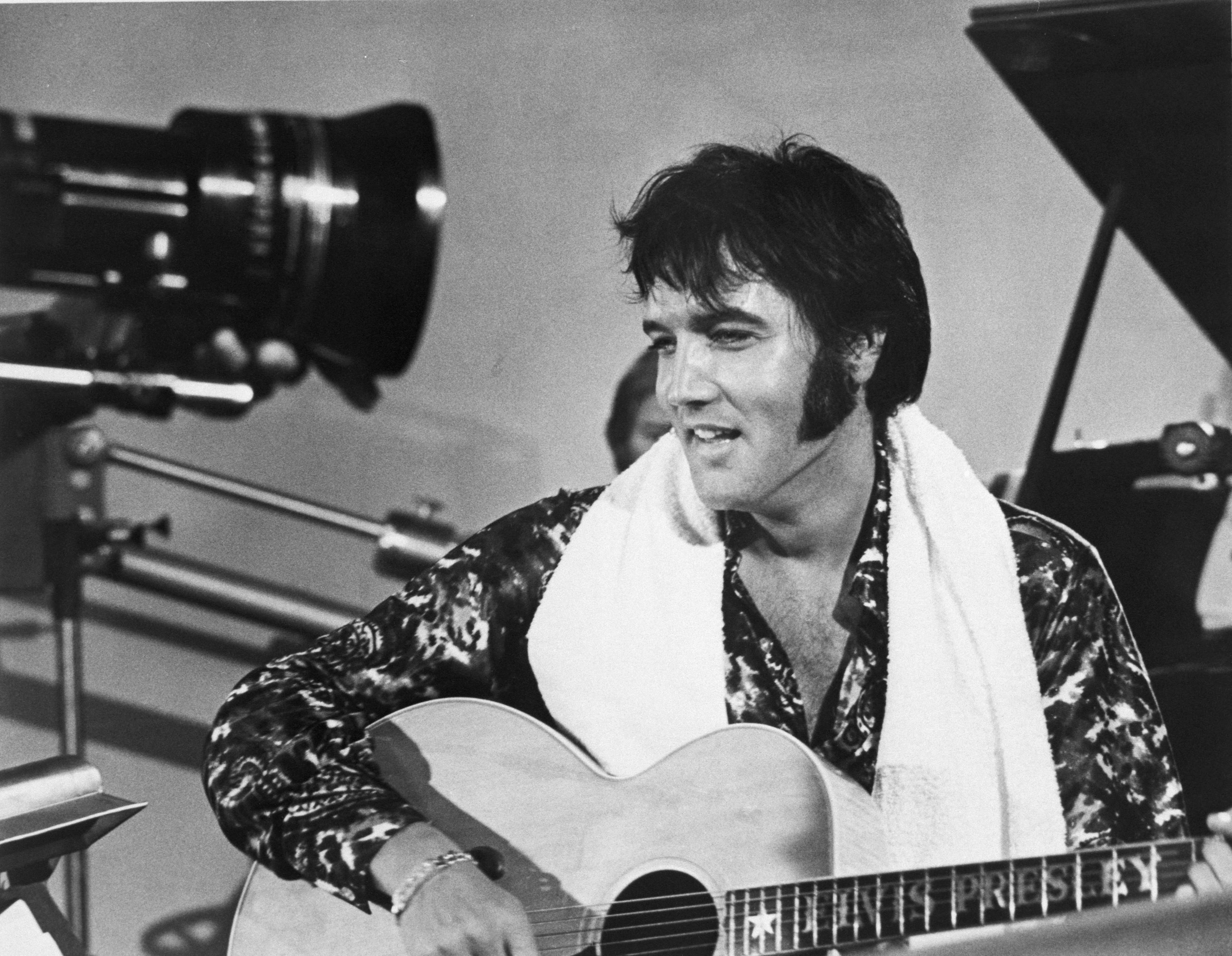 Elvis Presley jouant de la guitare durant une scène du documentaire Elvis: That's the Way It Is @ Bettmann / Getty Images
