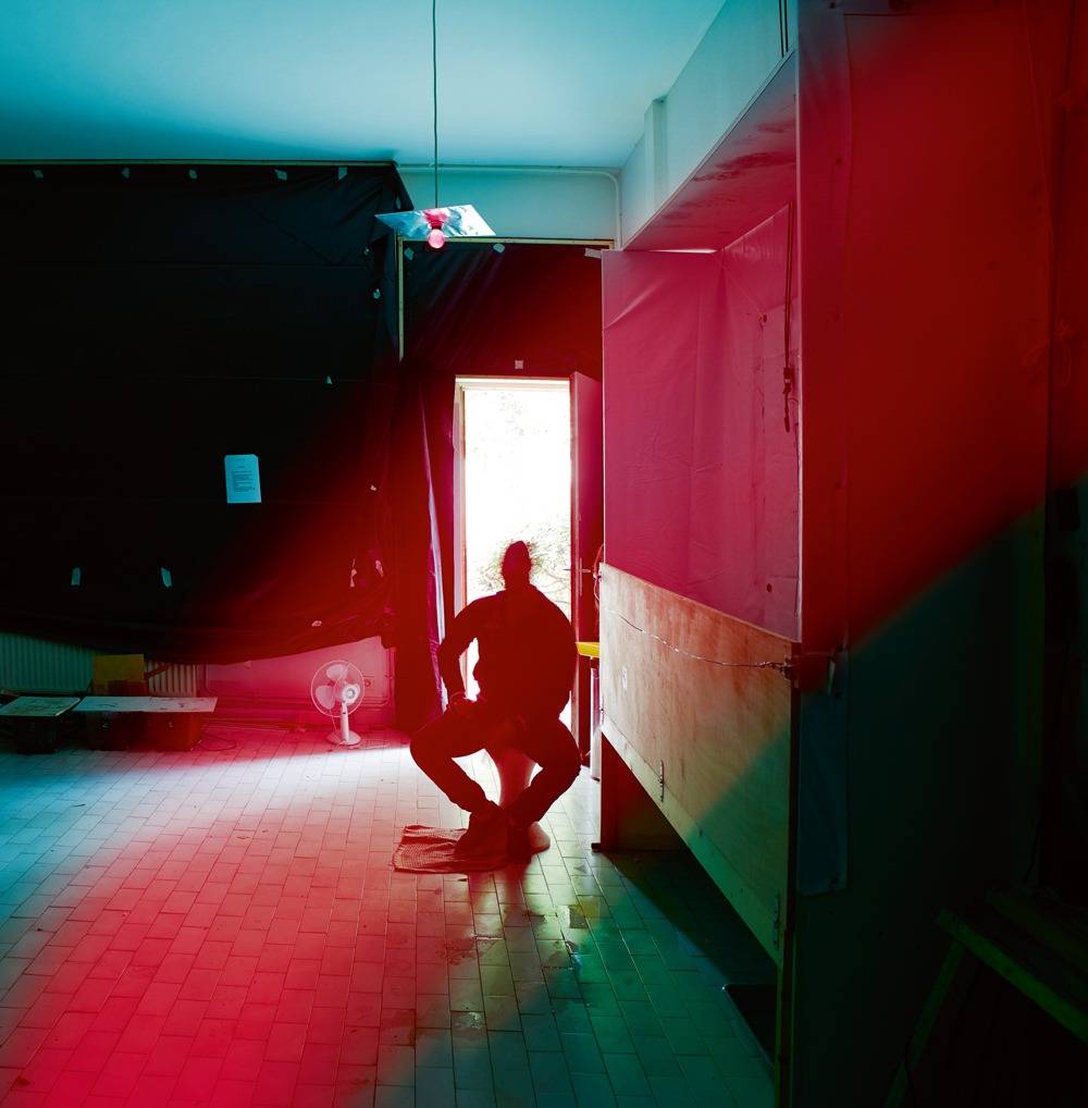 Mohamed Bourouissa, photographié dans son atelier de Gennevilliers. La première pièce a été transformée en chambre noire afin d’effectuer des tirages photographiques sur des carrosseries de voiture, en vue de son exposition à la galerie Kamel Mennour.