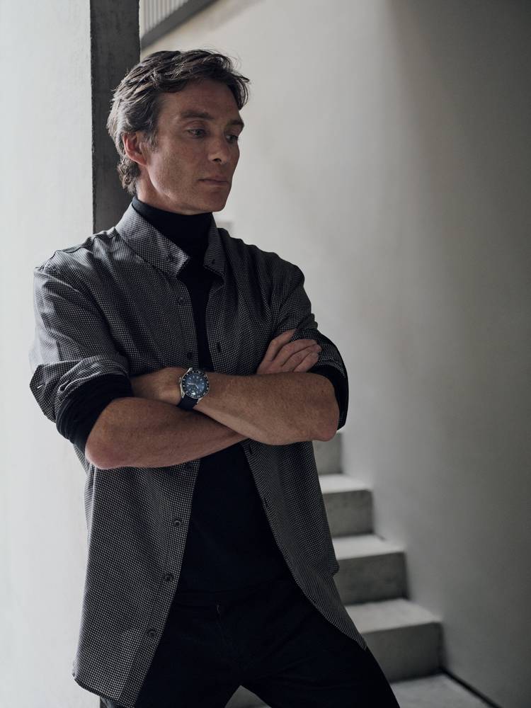 Cillian Murphy in a silk jacquard shirt, cashmere turtleneck and pants in cotton canvas, GIORGIO ARMANI. Watch “Montblanc 1858 GMT”, MONTBLANC.