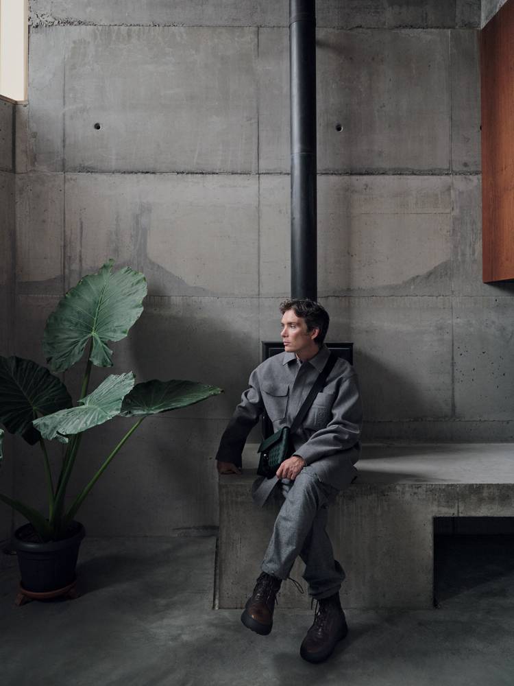 Cillian Murphy in an oversized bonded flannel shirt, woolen cloth trousers and boots, TOD’S. Pouch bag, MONTBLANC.