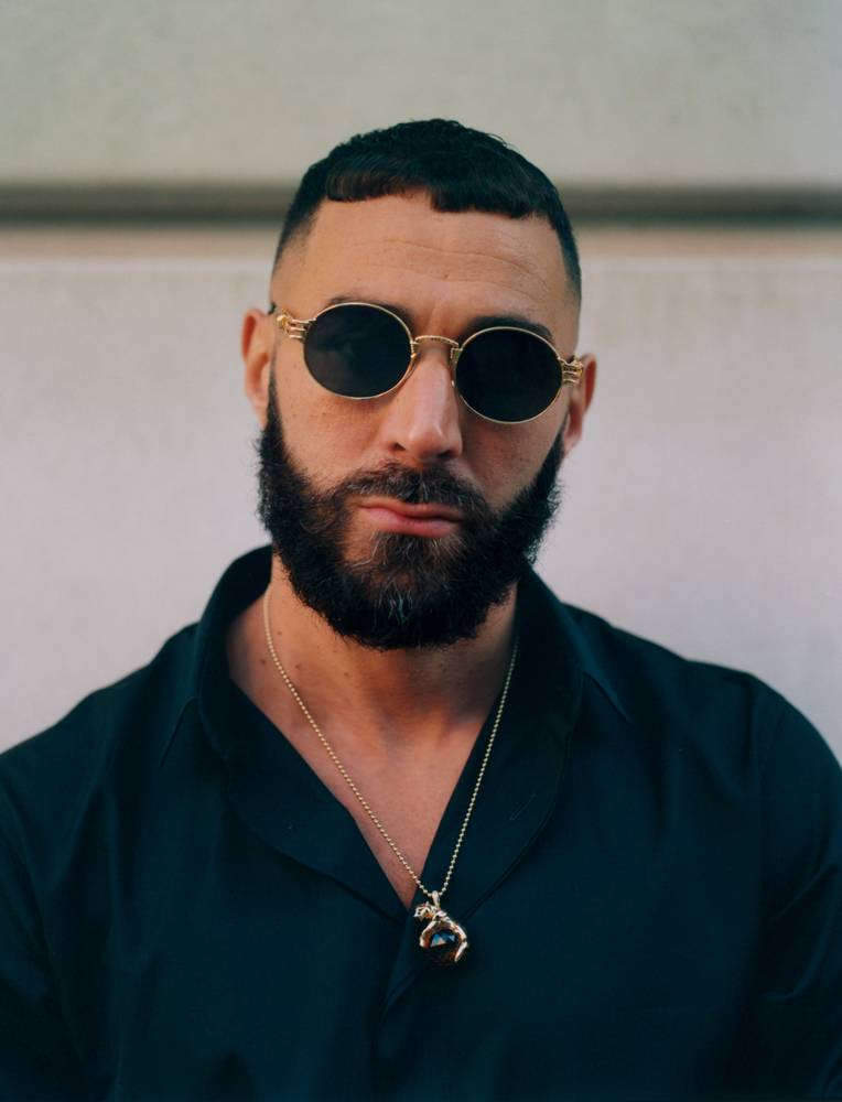 Karim Benzema, photographed July 8, 2022 in rue Jean-Giraudoux, Paris XVIe. Karim Benzema wears a cotton shirt, Collection Homme, DIOR, sunglasses, JEAN PAUL GAULTIER x KB and a chain and pendant, CARTIER. 
Retouche : Diamantino Labo Photo
