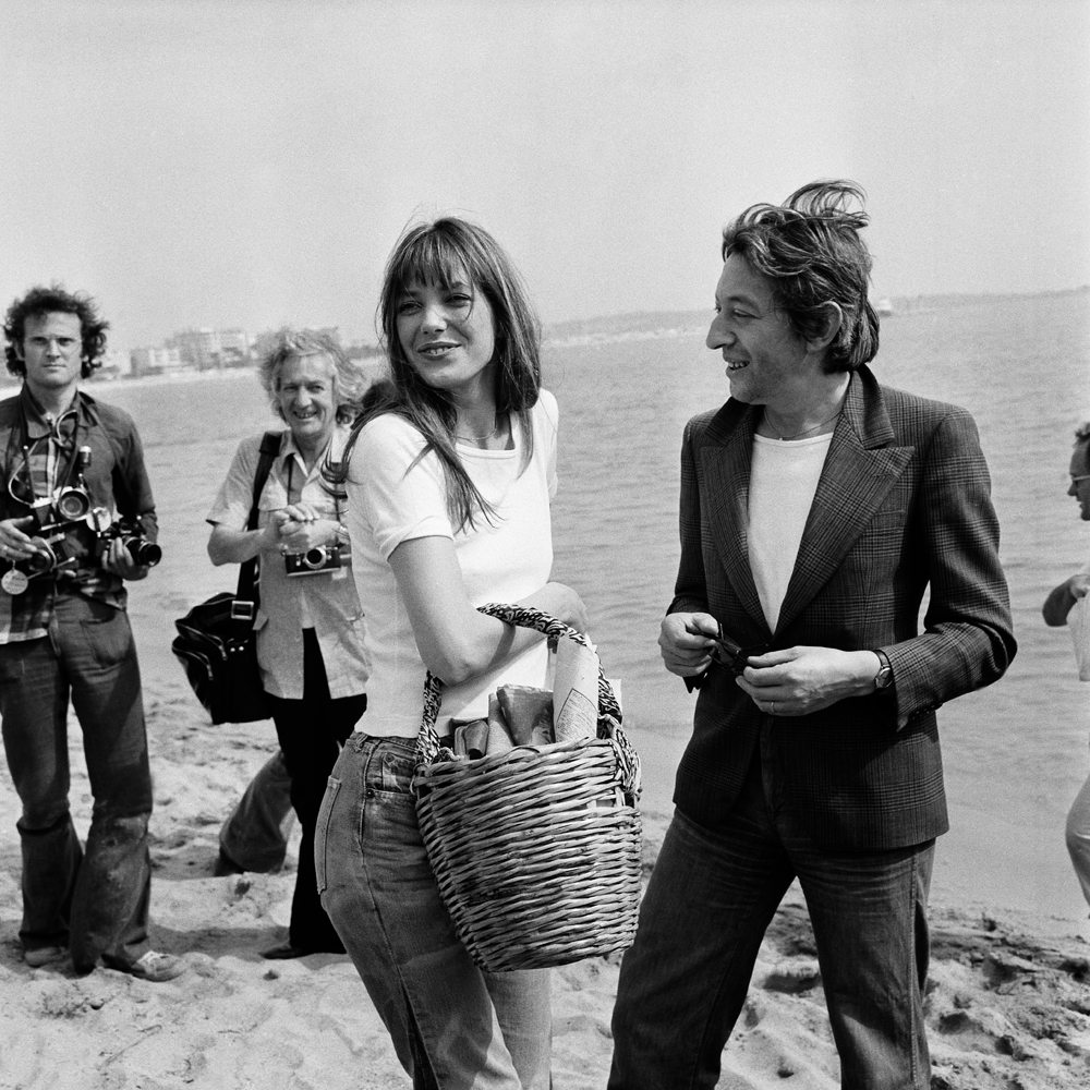 Serge Gainsbourg et Jane Birkin en jeans levi's 501 sur la plage à Cannes à l'occasion du Festival de Cannes en 1974. Photo by Gilbert TOURTE/Gamma-Rapho via Getty Images)