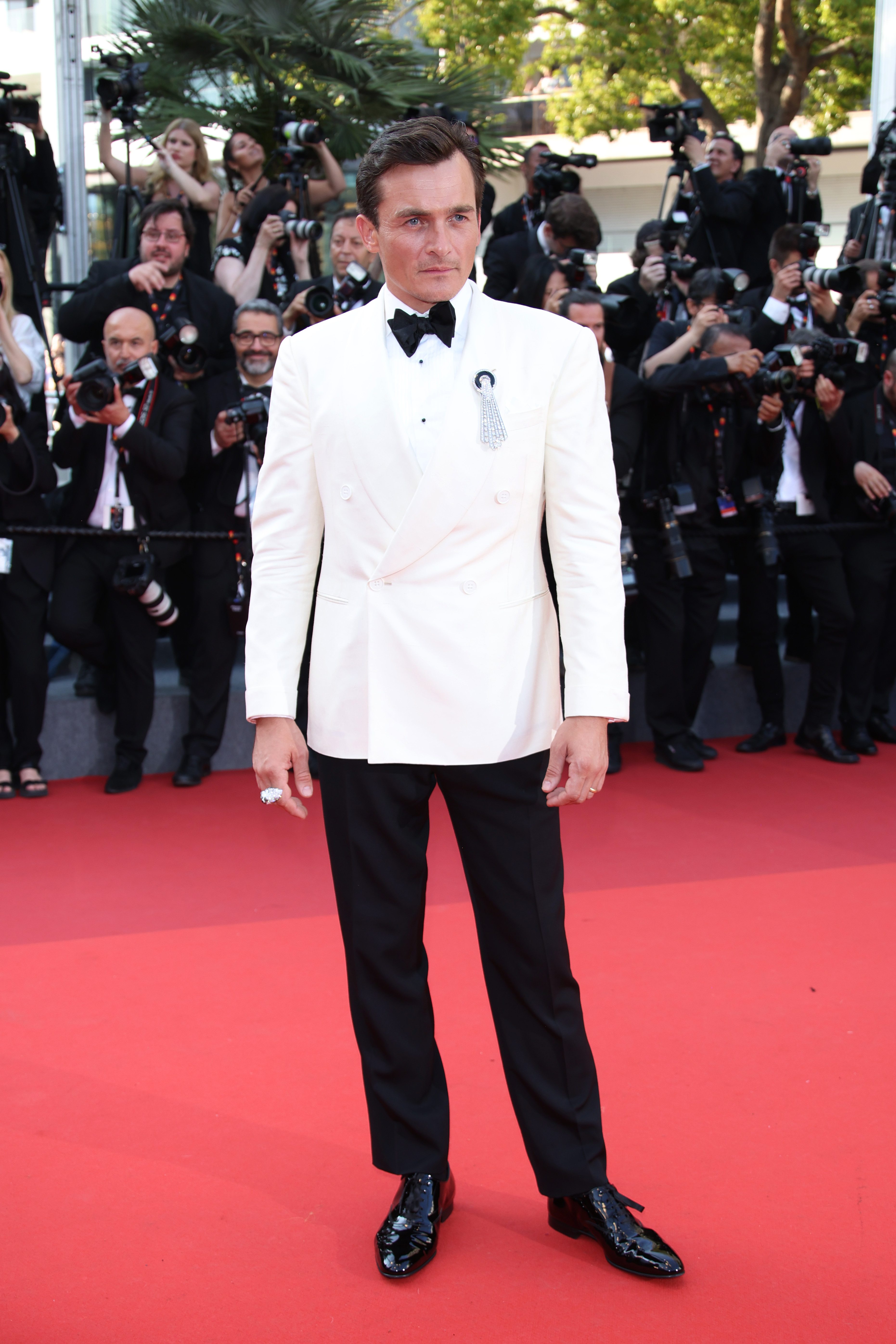 Rupert Friend avec une broche Boucheron sur le tapis rouge du Festival de Cannes 2023 © Getty Images