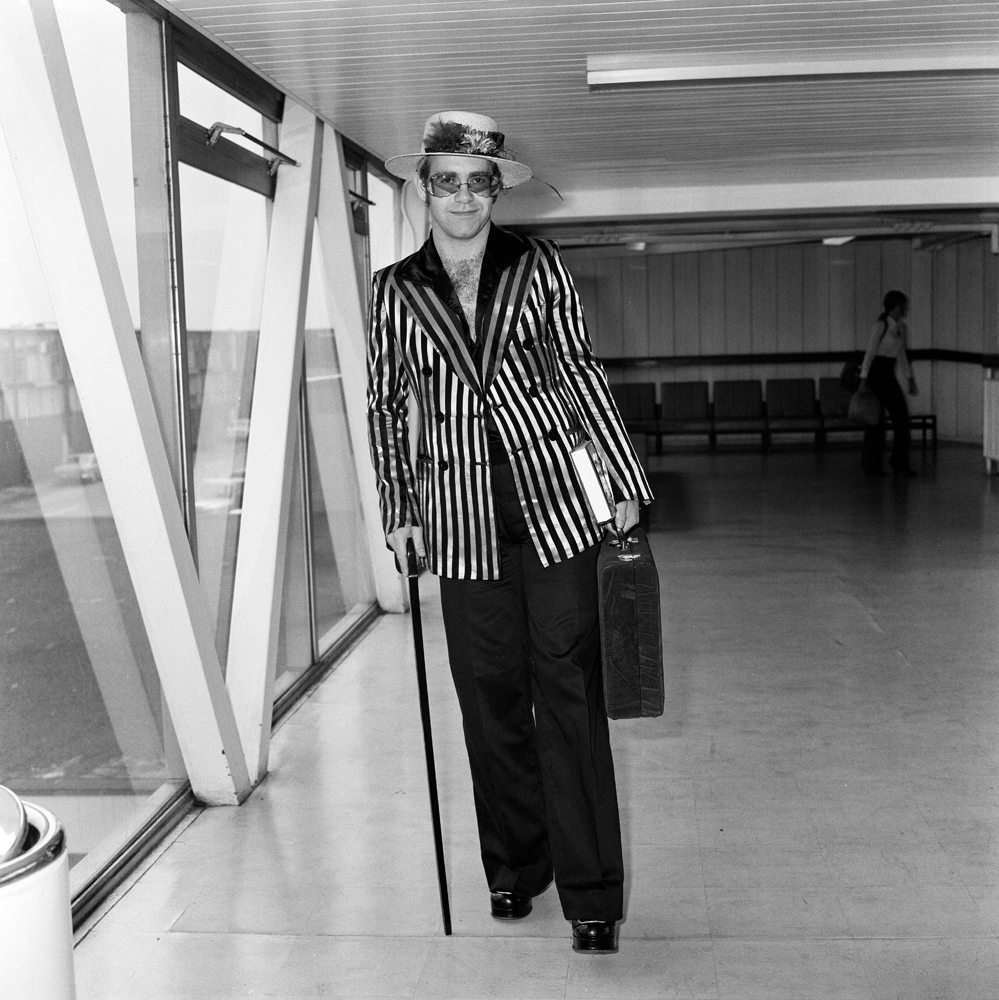 Elton John à l’aéroport d’Heathrow, au Royaume-Uni, le 30 août 1974. Photo par Dennis Stone/Mirrorpix/Getty Images