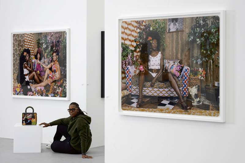 Mickalene Thomas photographiée devant ses œuvres sur le stand de la galerie Yancey Richardson à Miami Beach.
