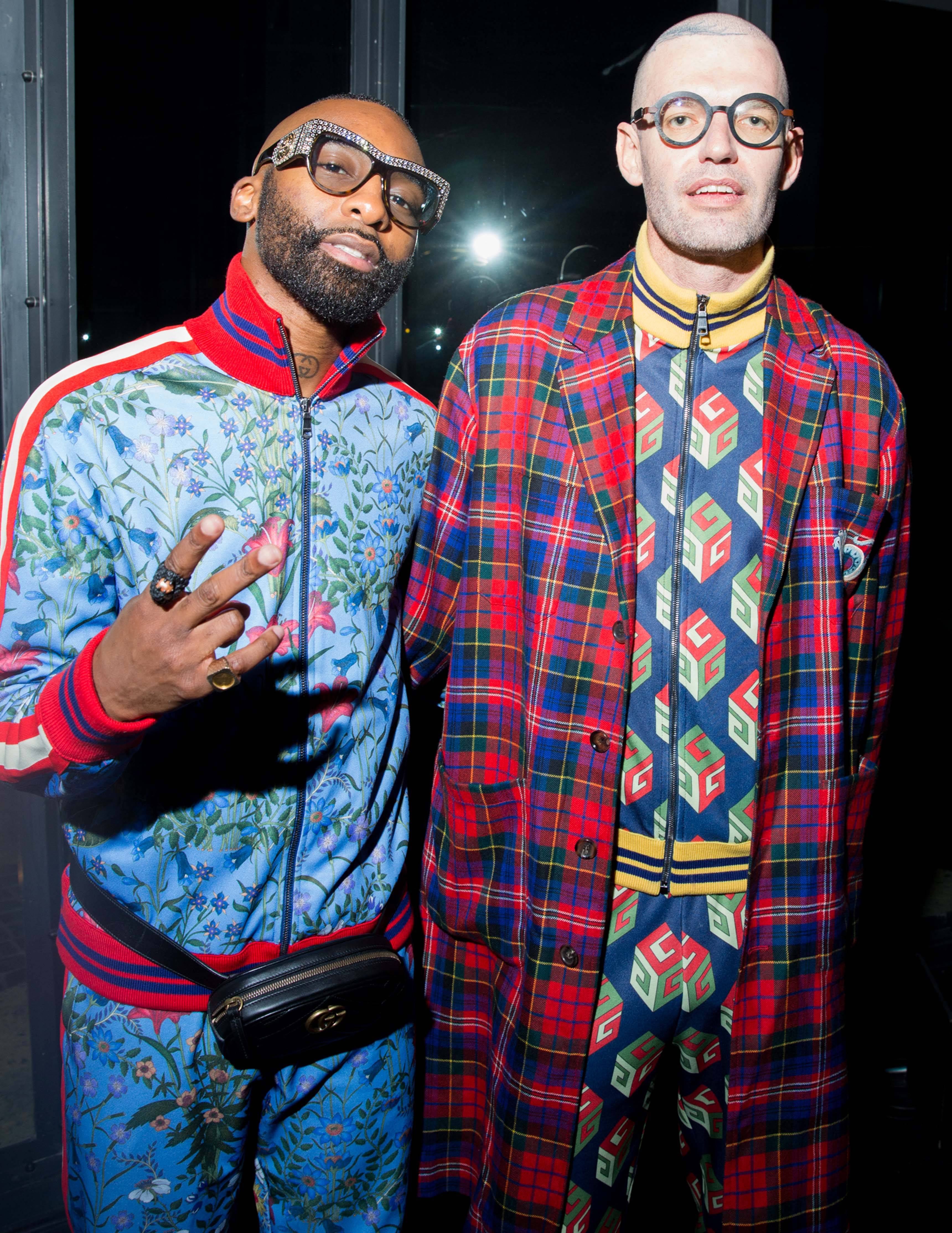 Riky Rick wore a Gucci Fall Winter 2017 azure macro new flora printed technical jersey zipped jacket and an azure macro new flora printed technical jersey jogging pants, a Pre Fall 2017 belt bag in black matelassé chevron leather with GG detail, and a Cruise 2017 leather sole moccasin in black leather with horsebit and Union Jack detail. Louw Kotzewore a Pre Fall 2017 royal bluette technical jersey zipped jacket with GG Wallpaper print and a royal bluette technical jersey jogging pants with GG Wallpaper print, a Pre Fall 2017 flare madras coat with embroidery detail, and Brixton mini GG wallpaper shoes.