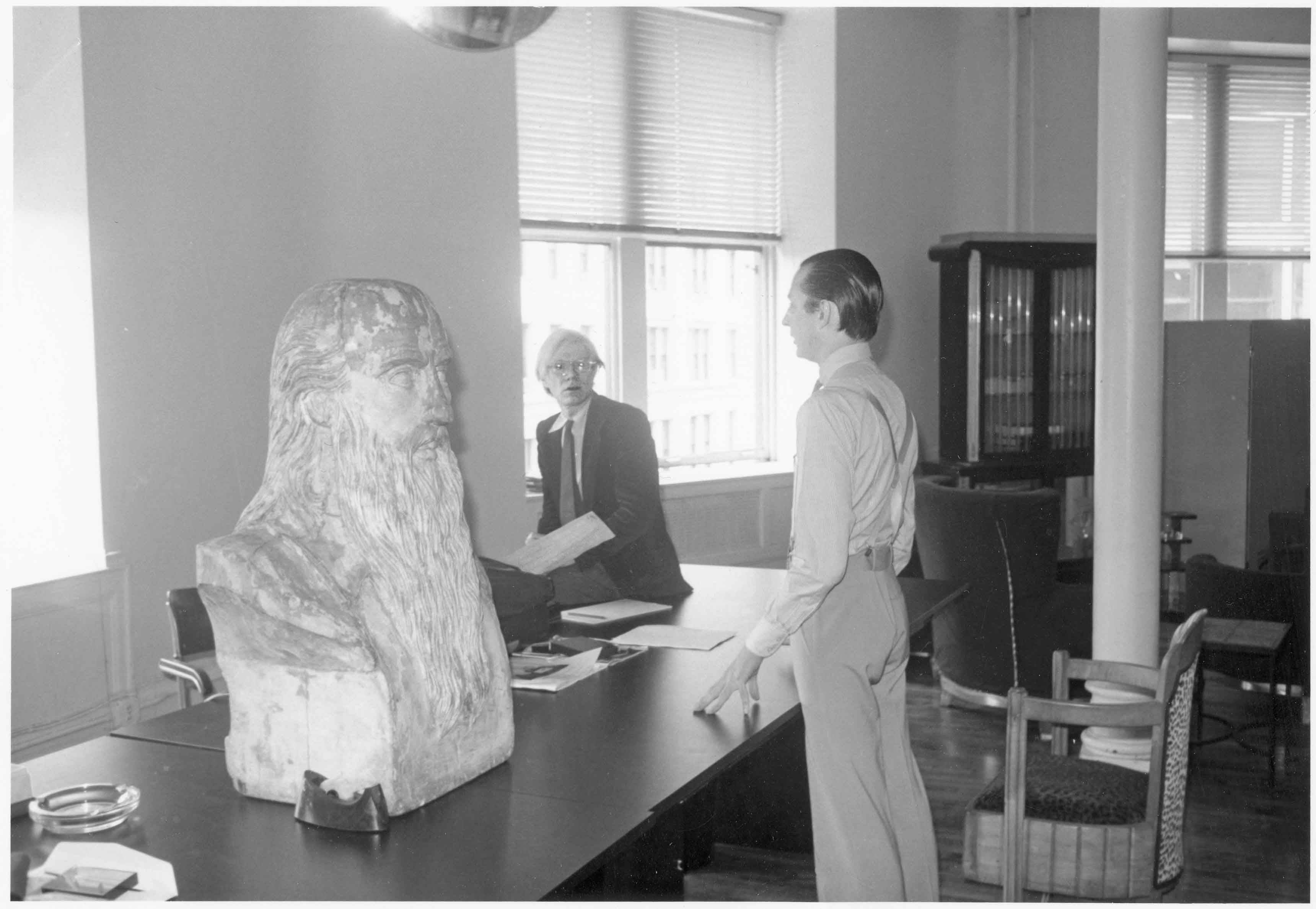 Andy et Fred Hughes, président d’Andy Warhol Enterprises, à la réception de la troisième Factory, au 860, Broadway, décorée d’un buste en bois de Léonard de Vinci. © Bob Colacello
