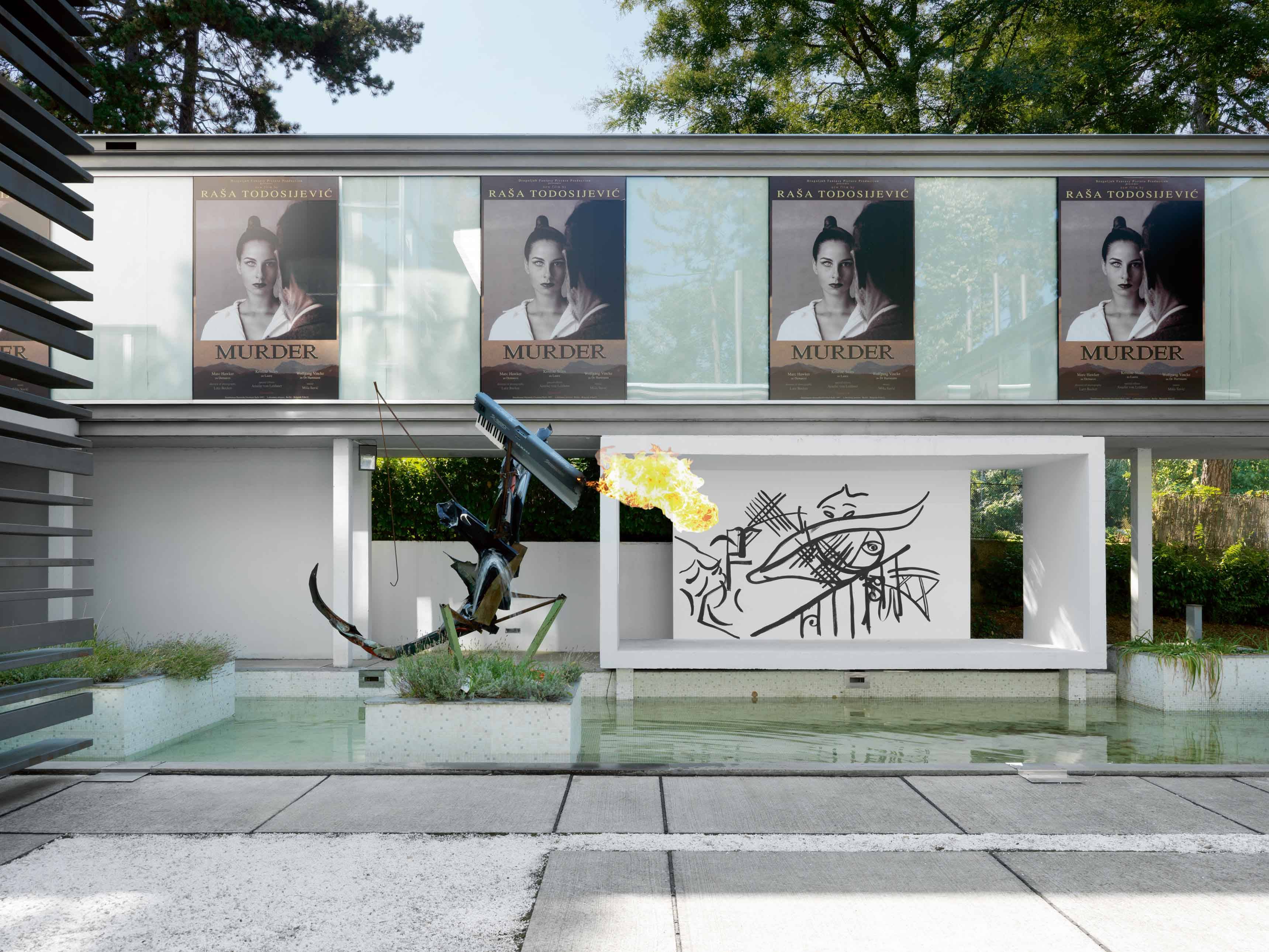 Vue de l’exposition Fade in 2 (affiches de Rasa Todosijevic et sculpture cracheuse de feu de Tobias Spichtig), dans une villa moderniste de Belgrade. 