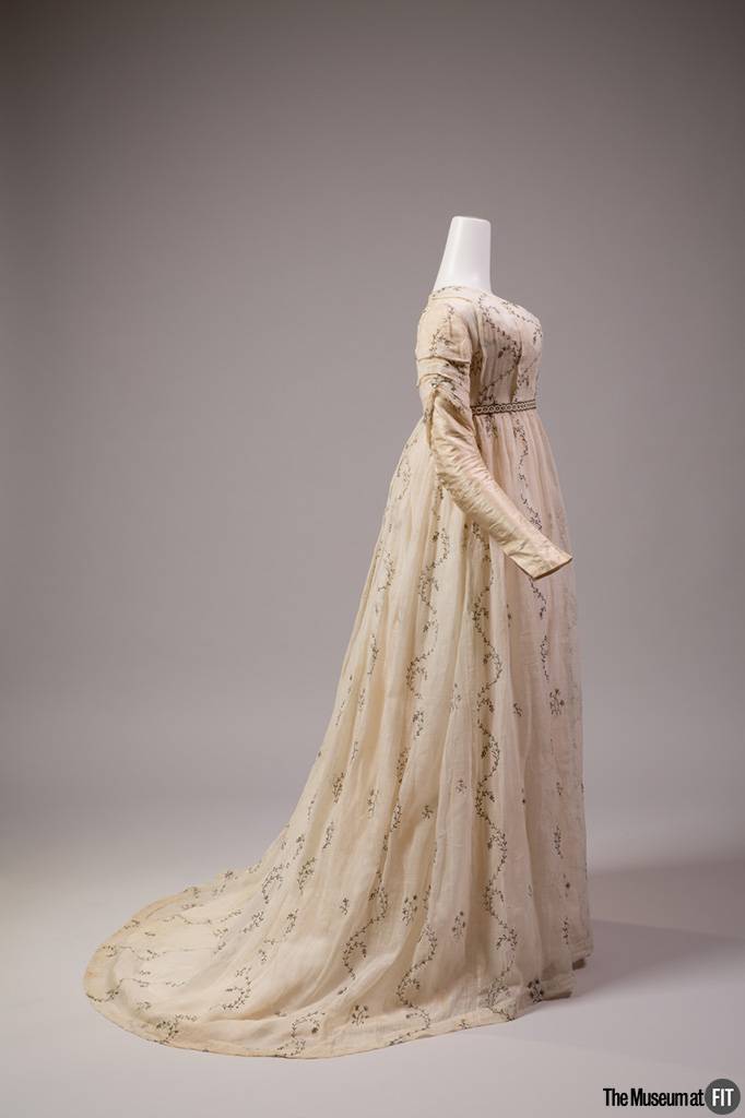 Robe ronde en “mousseline argentée” de coton blanc brodée de fil argenté et manches en taffetas de soie, datant de 1795-1800.