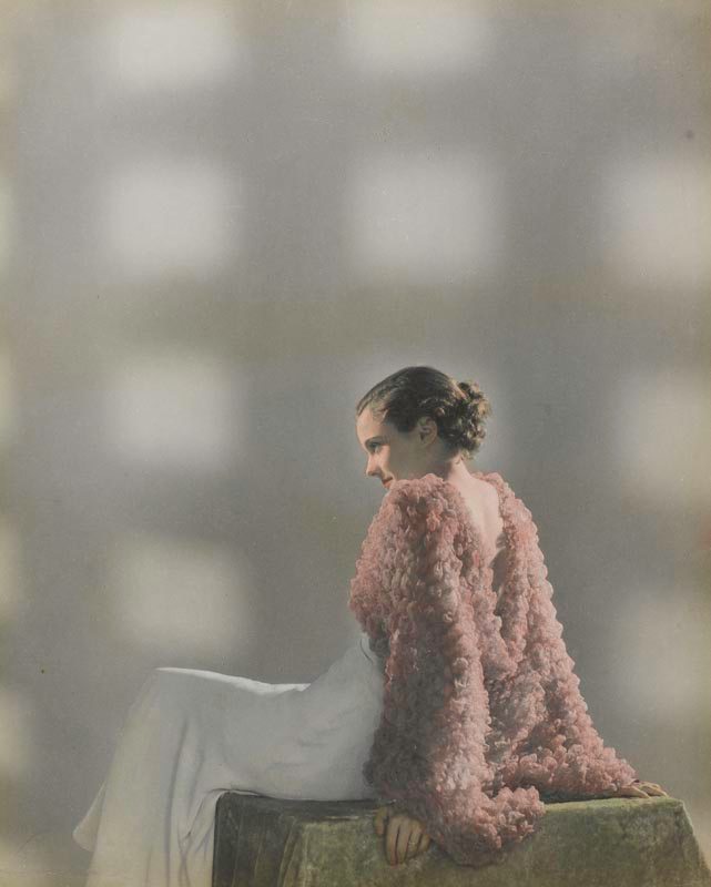 Dora Maar, photographie de mode, “Sans titre” [mannequin assise de profil en robe et veste de soirée] (vers 1932-1935). Épreuve gélatino-argentique rehaussée de couleurs.
