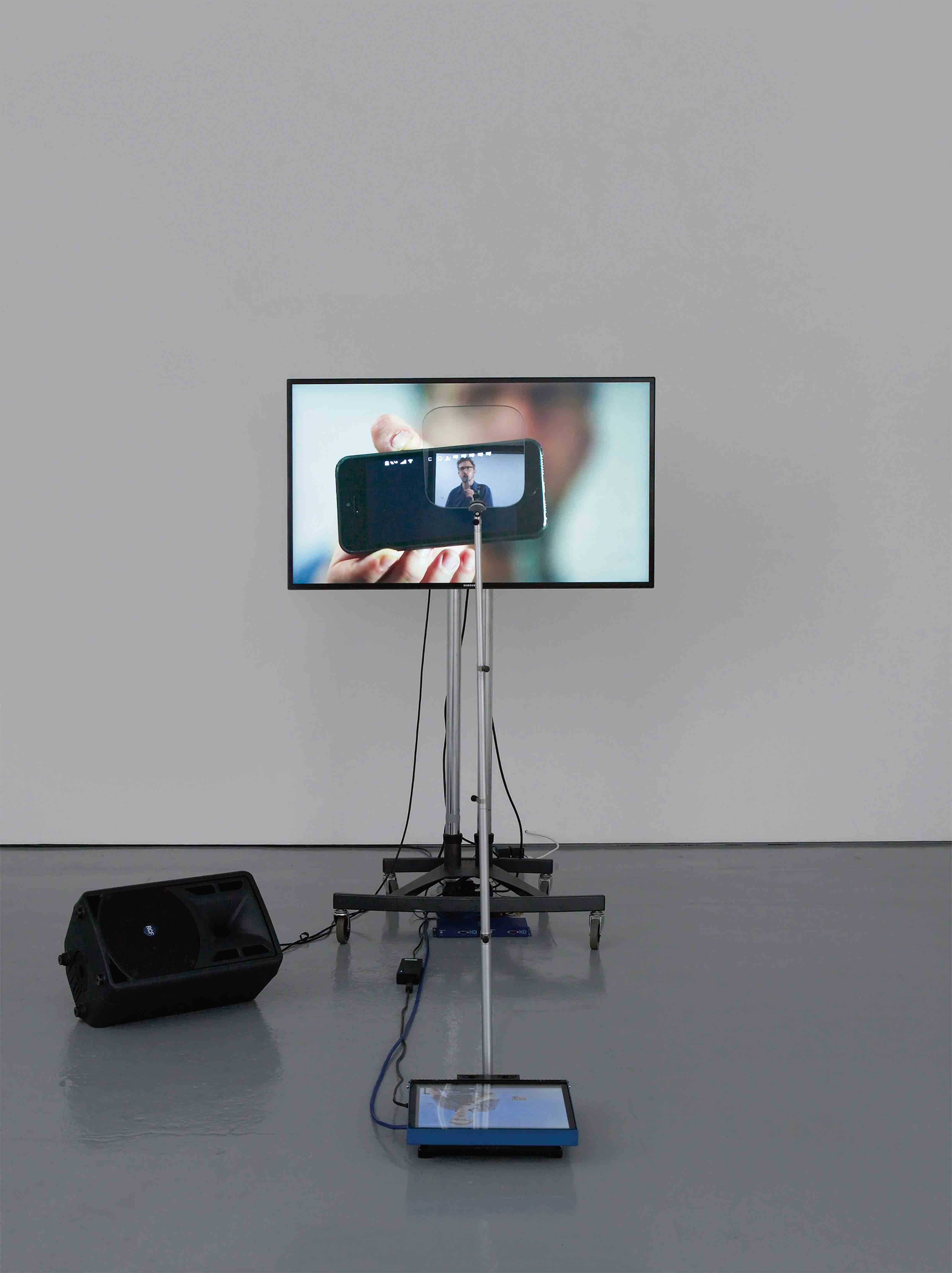 “Contra Diction” (Speech Against Itself) (2015), de Lawrence Abu Hamdan. Installation de deux vidéos, téléprompteur, écrans, micros, dimensions variables.