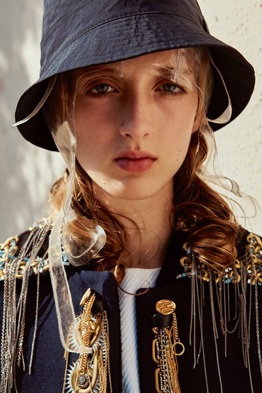 Wool and silk jacket embroidered with chains and pearls, and woolen top, LOUIS VUITTON. Bob, LACOSTE. Hat, MAISON MARGIELA.