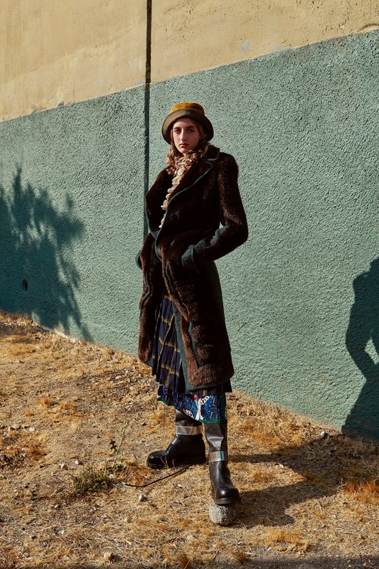 Imitation fur coat in mohair and cotton, ACNE STUDIOS. Ruffled cotton blouse, ZIMMERMANN. Checked wool skirt, CARVEN. Printed silk skirt, MSGM. Bob, LACOSTE. Boots, CALVIN KLEIN.
