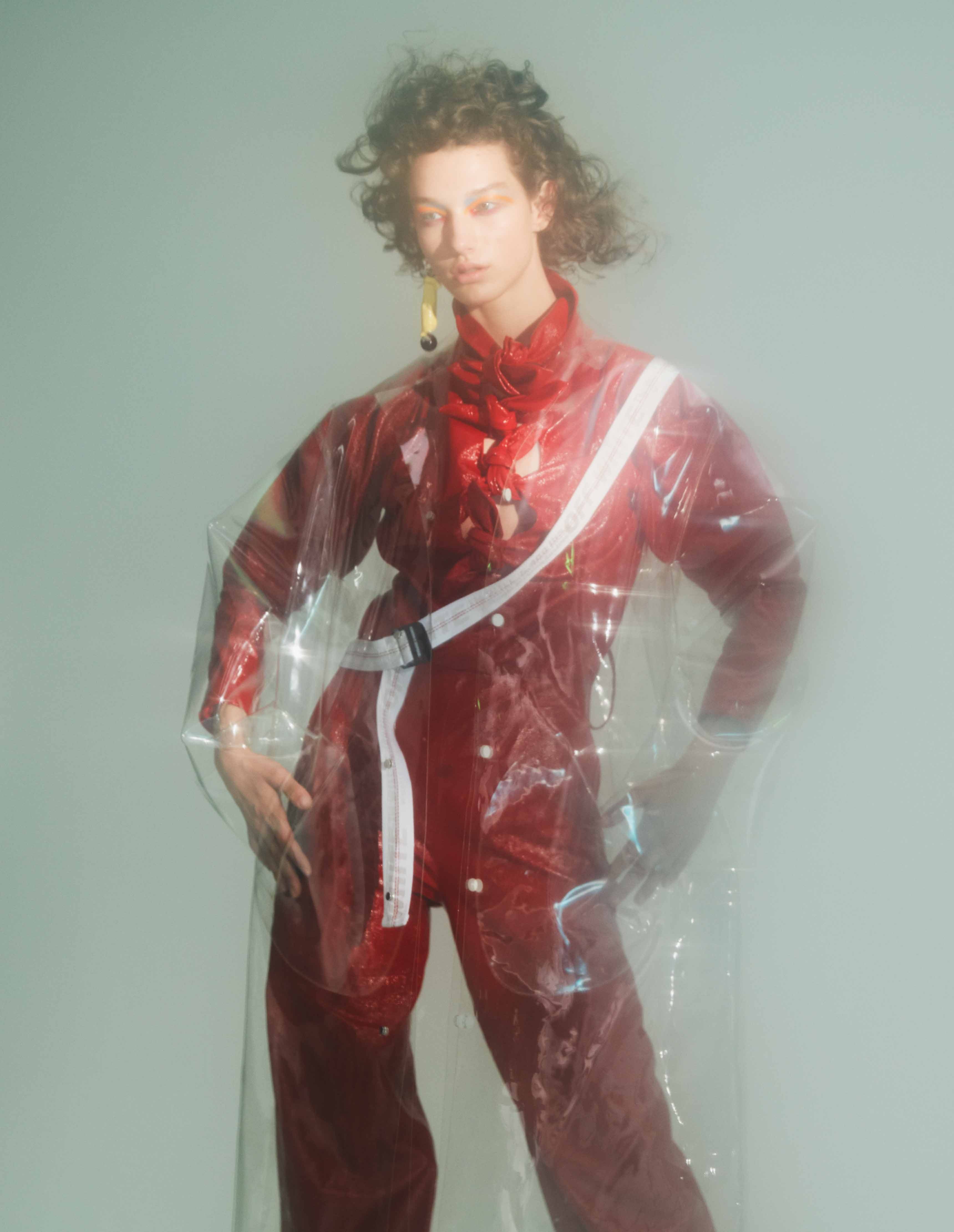 McKenna Hellam photographiée par Benjamin Lennox porte Combinaison-pantalon en cuir verni, DROME. Trench en PVC, OFF-WHITE C/O VIRGIL ABLOH. Boucle d’oreille, MARNI. 