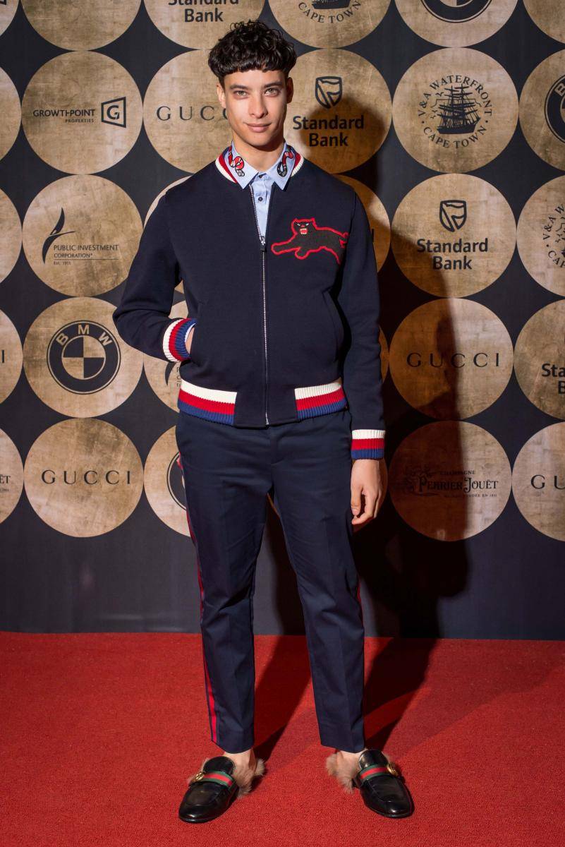 <p>Jody Paulsen wore a Gucci Pre Fall 2017 navy bomber jacket with white, red, and blue web and an embroidered panther, blue cotton pants with bordeaux web, white pin-point duke shirt with collar embroidery, and a black leather princetown shoes with web, GG detail and natural fur.</p>
